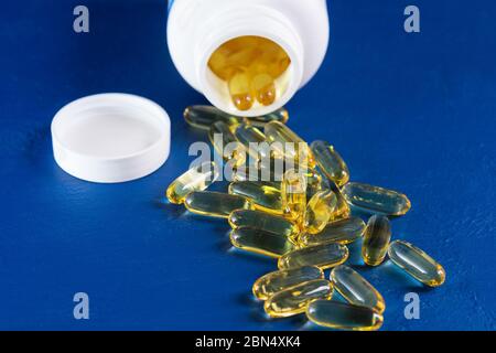 Molte capsule Omega 3 su sfondo blu. Primo piano, prodotto ad alta risoluzione. Concetto di assistenza sanitaria Foto Stock