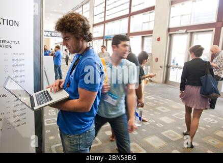 Austin Texas USA, 12 marzo 2012: Un giovane partecipante alla conferenza SXSW Interactive utilizza il suo computer portatile per controllare il programma all'Austin Convention Center. ©Marjorie Kamys Cotera/Daemmrich Photography Foto Stock