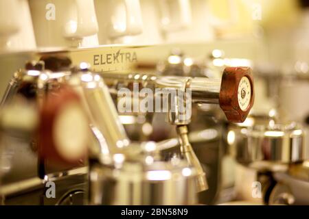 Da vicino una macchina da caffè con tazze bianche sulla parte superiore del ripiano sopra i denti di rilascio del vapore, Foto Stock