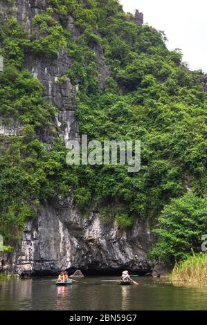 Provincia di Ninh Binh, Vietnam - 22 ottobre 2019: Giro in barca TAM Coc. grotta sul fiume. Turisti in barca a esplorare lo scenario NGO Dong River. Foto Stock