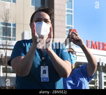 Racine, Wisconsin, Stati Uniti. 12 maggio 2020. DR. DIANA TURNER reagisce come quattro F-16 Fighting Falcon caccia jet dal Wisconsin Air National Guard Flyer Ascension All Saints Hospital a Racine, Wisconsin Martedì sera 12 maggio 2020 come un tributo ai soccorritori in prima linea nella crisi di Coronavirus. Era uno dei 21 flyovers del centro medico e dell'ospedale in operazione americana risolve in Wisconsin Martedì. Credit: Mark Hertzberg/ZUMA Wire/Alamy Live News Foto Stock