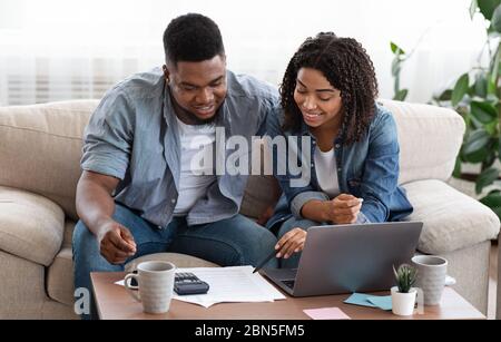 Giovani coniugi africani che gestiscono insieme il loro bilancio familiare in patria Foto Stock