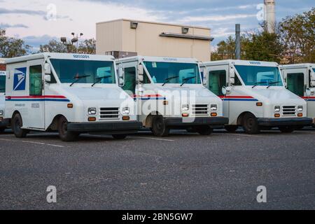 Un numero parcheggiato furgoni dei servizi postali degli Stati Uniti di fronte a un ufficio postale Foto Stock