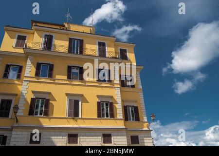 Edificio giallo a più piani in una giornata luminosa e semi nuvolosa Foto Stock