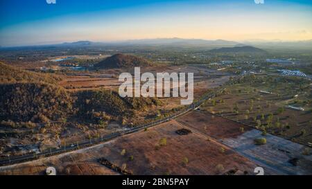 Questa foto unica mostra il paesaggio posteriore di Hua Hin in Thailandia al tramonto con un grande cielo. In primo piano la strada di campagna! Foto Stock
