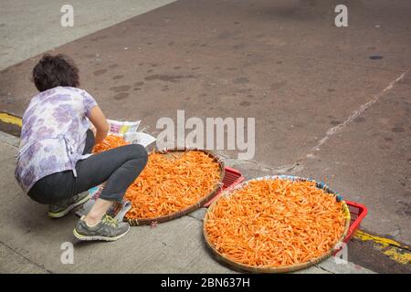 La donna cinese vende gamberetti secchi nelle strade di Hong Kong Foto Stock