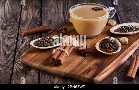 Bevanda indiana tradizionale - tè masala con spezie. Cannella, cardamomo, anice, zucchero, chiodi di garofano, pepe su sfondo di legno scuro. Spazio di copia. Vista laterale Foto Stock