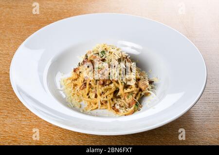 Spaghetti carbonara, autentico piatto tipico italiano a base di: Pancetta, uova, scaglie di parmigiano, prezzemolo, formaggi stagionati, salumi. Italiano p Foto Stock