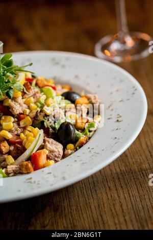 Insalata di Tun con olive, mais e razzo sul tavolo Foto Stock