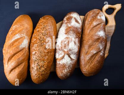 Molti pane e panini misti girato dall'alto. Vista dall'alto dell'assortimento di diversi tipi di panetteria: Pane, pasties, panini, pretzel e croissant Foto Stock