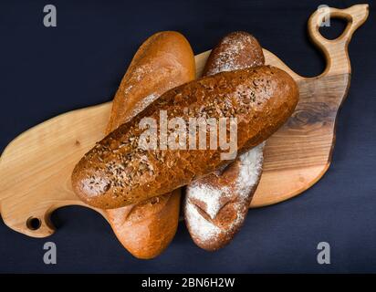 Molti pane e panini misti girato dall'alto. Vista dall'alto dell'assortimento di diversi tipi di panetteria: Pane, pasties, panini, pretzel e croissant Foto Stock