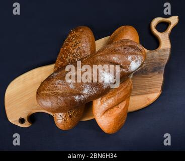 Molti pane e panini misti girato dall'alto. Vista dall'alto dell'assortimento di diversi tipi di panetteria: Pane, pasties, panini, pretzel e croissant Foto Stock