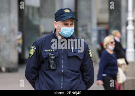 Zagabria, Croazia - 01 maggio 2020 : il poliziotto indossa una maschera protettiva per la medicina a causa del coronavirus per le strade di Zagabria, Croazia. Foto Stock