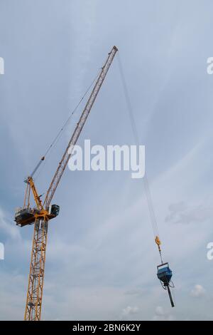 Gru da costruzione che sposta un supporto di materiale da costruzione. Foto Stock