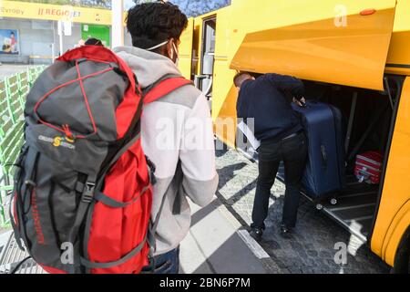 Praga, Repubblica Ceca. 13 maggio 2020. Un autista, a destra, carica i bagagli nel primo autobus RegioJet, che ha lasciato Praga per la Germania dopo il permesso di trasporto internazionale di passeggeri, il 13 maggio 2020, a Praga, Repubblica Ceca. Tredici persone, per lo più stranieri, viaggiarono da Praga a Dresda e Berlino. Si tratta del primo collegamento rinnovato dopo il divieto del traffico internazionale dovuto alla pandemia di coronavirus. Credit: Michal Kamaryt/CTK Photo/Alamy Live News Foto Stock