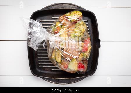 Verdure non cotte con pezzi di carne in padella nel sacchetto da forno. Vista dall'alto . Foto Stock