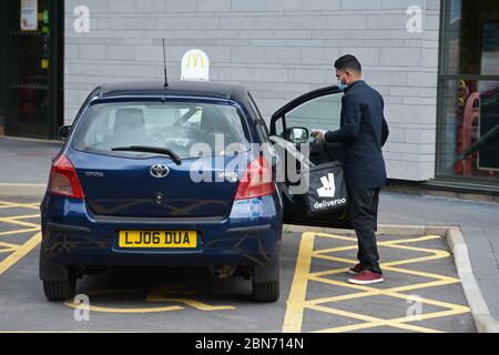 Un lavoratore di Deliveroo lascia una filiale di McDonald's a Boreham, Chelmsford, Essex, una delle 15 sedi della catena di ristoranti per riaprirsi per il decollo. Foto Stock