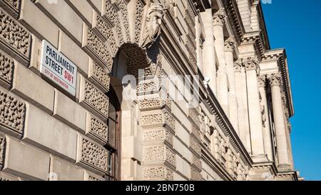 Parliament Street e Whitehall sono sinonimo di governo britannico. L'insegna della strada è adiacente a HM Treasury, conosciuto come lo scacchiere. Foto Stock