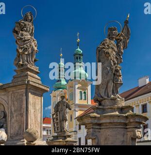 Statue alla colonna della peste, Chiesa dell'Assunzione dietro, a Hradec Kralove, Boemia, Repubblica Ceca, Europa Centrale Foto Stock