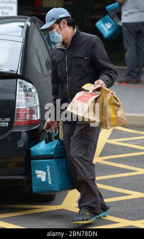 Un lavoratore di Deliveroo lascia una filiale di McDonald's a Boreham, Chelmsford, Essex, una delle 15 sedi della catena di ristoranti per riaprirsi per il decollo. Foto Stock