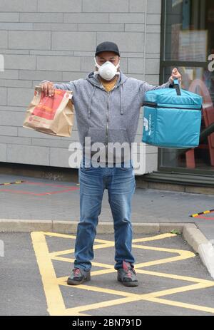 Un lavoratore di Deliveroo lascia una filiale di McDonald's a Boreham, Chelmsford, Essex, una delle 15 sedi della catena di ristoranti per riaprirsi per il decollo. Foto Stock