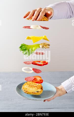 sandwich volante. Strati volanti di sandwich. Ben arrostito patty, Pram, formaggio e verdure tra due metà di un. Concetto di cibo per colazione americana. Foto Stock