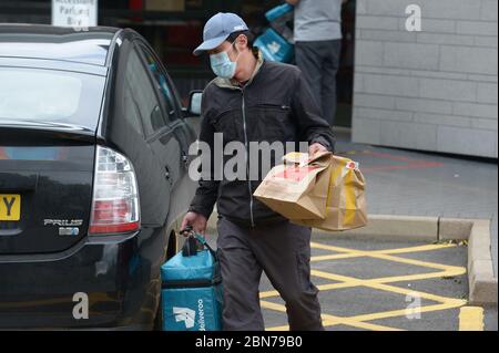 Un lavoratore di Deliveroo lascia una filiale di McDonald's a Boreham, Chelmsford, Essex, una delle 15 sedi della catena di ristoranti per riaprirsi per il decollo. Foto Stock
