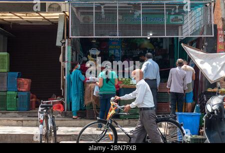 La gente che compra le verdure con il mantenimento di distanza sociale e indossare la maschera per prevenire dal virus Foto Stock