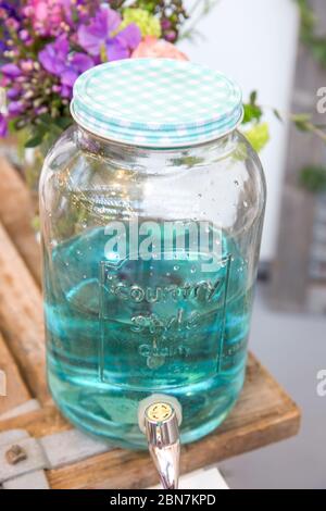 Vaso in vetro vintage stile country con coperchio bianco e blu contenente bevanda turchese Foto Stock