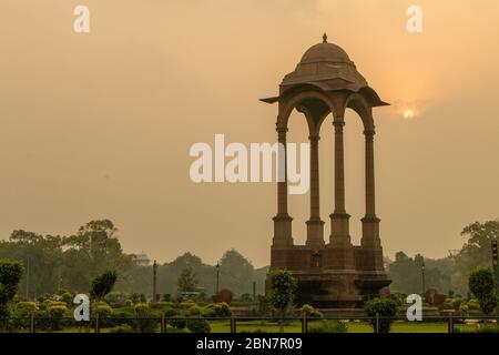 India Gate, Nuova Delhi: Amar Jawan Jyoti. Sole che sorge dietro la silhouette di Amar Jawan Jyoti all'India Gate Foto Stock
