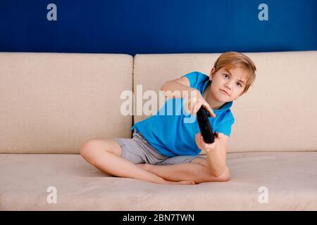 Ragazzo in blu t-shirt tenendo controller di gioco video divertirsi giocando video gioco sul computer. Foto Stock