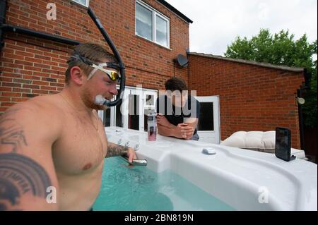 Il nuotatore britannico Adam Peaty accanto ed Baxter parla di allenatore Mel Marshall mentre si allena a casa sua a Loughborough in piscina fornita da Jacuzzi in collaborazione con le vasche idromassaggio Bedfordshire per consentire ai nuotatori olimpici del GB di continuare ad allenarsi a casa per Tokyo 2021 durante l'attuale blocco del Regno Unito. Foto Stock