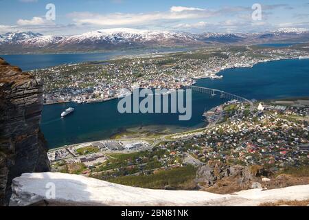 Tromso, nella contea di Troms andare Finnmark, Norvegia, visto in un tiro aereo con una parte del punto di vista della montagna in primo piano Foto Stock