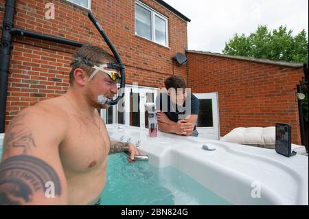 Il nuotatore britannico Adam Peaty accanto ed Baxter parla di allenatore Mel Marshall mentre si allena nella sua casa a Loughborough in piscina fornita da Jacuzzi in collaborazione con le vasche idromassaggio Bedfordshire per consentire ai nostri nuotatori olimpici del GB di continuare ad allenarsi a casa per Tokyo 2021 durante l'attuale Regno Unito blocco. Foto Stock