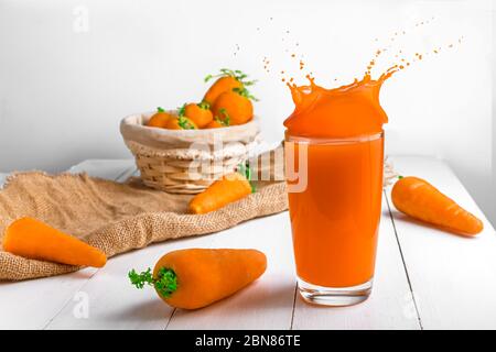 succo di carota con spruzzi. sfondo bianco Foto Stock