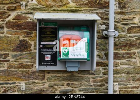 Defibrillatore salvavita di emergenza in un luogo pubblico presso il bar Stables della Penrose Estate, Cornovaglia, Inghilterra Regno Unito Foto Stock