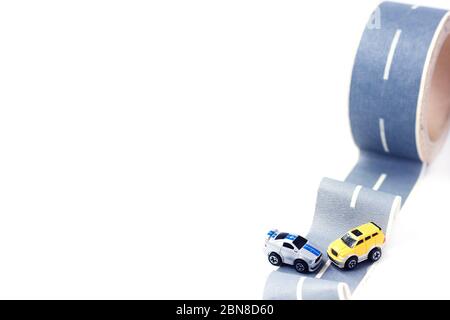 Incidente stradale. Due modelli di giocattoli su nastro per condotti. Strada sdrucciolevole o accidentata. Assicurazione. Incidente Foto Stock