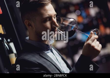 Enologo sommelier uomo sniffing aroma vino rosso in vetro Foto Stock