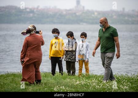 Istanbul, Turchia. 13 maggio 2020. I bambini camminano in un parco vicino al lago Kucukcekmece a Istanbul, Turchia, 13 maggio 2020. I bambini di età inferiore ai 14 anni in Turchia sono stati ammessi all'esterno mercoledì per la prima volta in 40 giorni nell'ambito del piano di normalizzazione COVID-19 del paese. Credit: Yasin Akgul/Xinhua/Alamy Live News Foto Stock