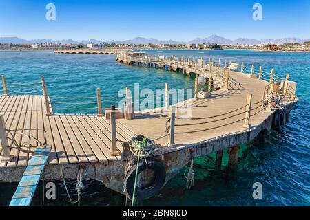 Paesaggio con molo in legno curvo in blu mare egiziano Foto Stock