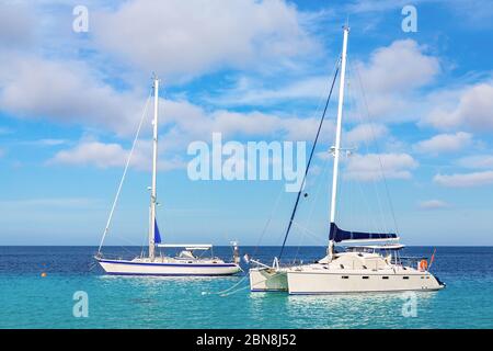 Due barche a vela galleggianti su acque blu vicino alla costa di Bonaire Foto Stock