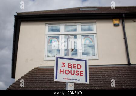 West Norwood, Regno Unito. 13 maggio 2020. Un cartello ‘3 bed house’ fuori da una casa con disegni arcobaleno nella finestra di West Norwood durante la pandemia di Coronavirus nel sud di Londra, Inghilterra. (Foto di Sam Mellish / Alamy Live News) Foto Stock