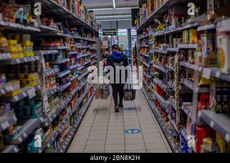 West Norwood, Regno Unito. 13 maggio 2020. Una signora che fa shopping seguendo i segni di distanza sociale in senso unico nel supermercato Co-op a West Norwood durante la pandemia di Coronavirus a Londra del sud, Inghilterra. (Foto di Sam Mellish / Alamy Live News) Foto Stock