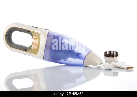 Aspirapolvere manuale con accessori su fondo lucido bianco. Foto Stock