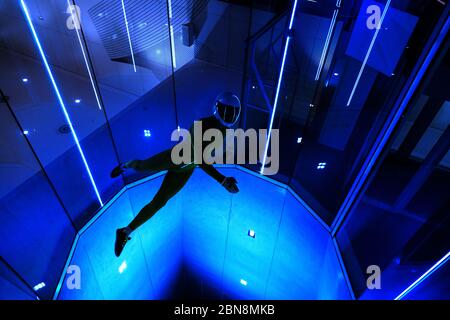 Un uomo che fa acrobazie in una galleria del vento interna Foto Stock