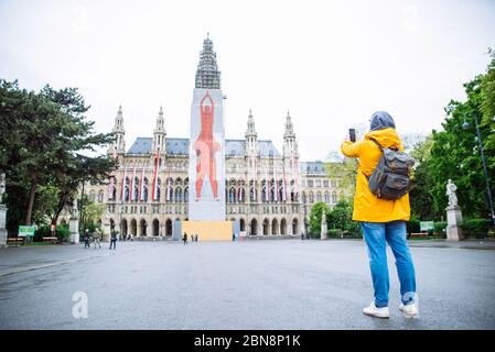 Vienna, Austria - 16 maggio 2019: uomo turistico viaggiatore che prende foto al telefono vienna City Hall sullo sfondo Foto Stock