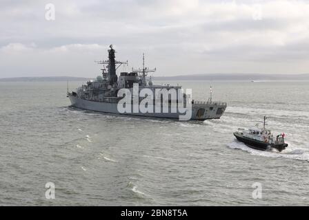 Un pilota di Ammiralty scorta la Royal Navy Frigate HMS SUTHERLAND mentre lascia Portsmouth Naval base dopo una breve sosta per carburante e negozi Foto Stock