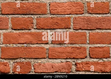 Sfondo con struttura in mattoni rosso scuro senza cuciture per il design. Modello di vecchio muro di brickwall rotto con agenti atmosferici. Muro di pietre impilate. Muro di lavoro in mattoni da vecchio Foto Stock