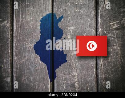 Mappa e bandiera della Tunisia su sfondo ligneo Foto Stock