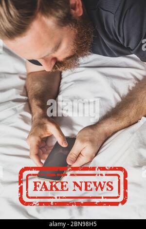 Infodemiche notizie false durante il concetto pandemico Covid-19. Uomo mani che tengono il telefono cellulare a leggere notizie globali o social network a casa. Lettura ultime notizie upd Foto Stock